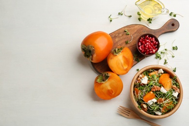 Photo of Delicious persimmon salad served on white wooden table, flat lay. Space for text