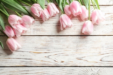 Photo of Beautiful tulips for Mother's Day on wooden background, top view