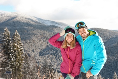 Photo of Happy couple spending winter vacation in mountains. Space for text