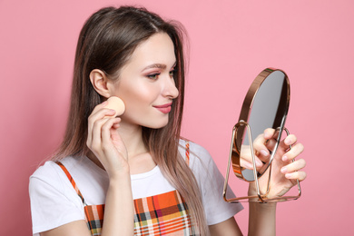 Photo of Beauty blogger doing make up on pink background