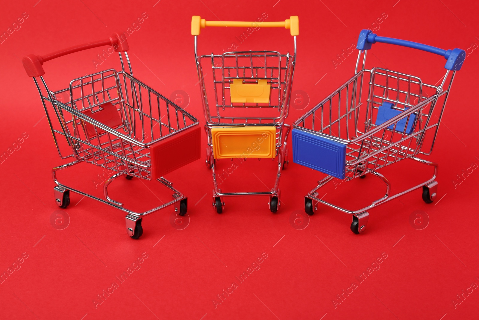 Photo of Different empty shopping trolleys on color background