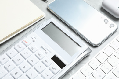 Photo of Calculator, smartphone and keyboard on grey table, closeup. Tax accounting
