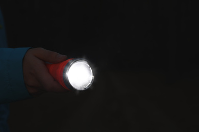 Photo of Man with bright flashlight at night, closeup. Space for text