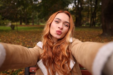 Photo of Portrait of beautiful woman taking selfie in autumn park