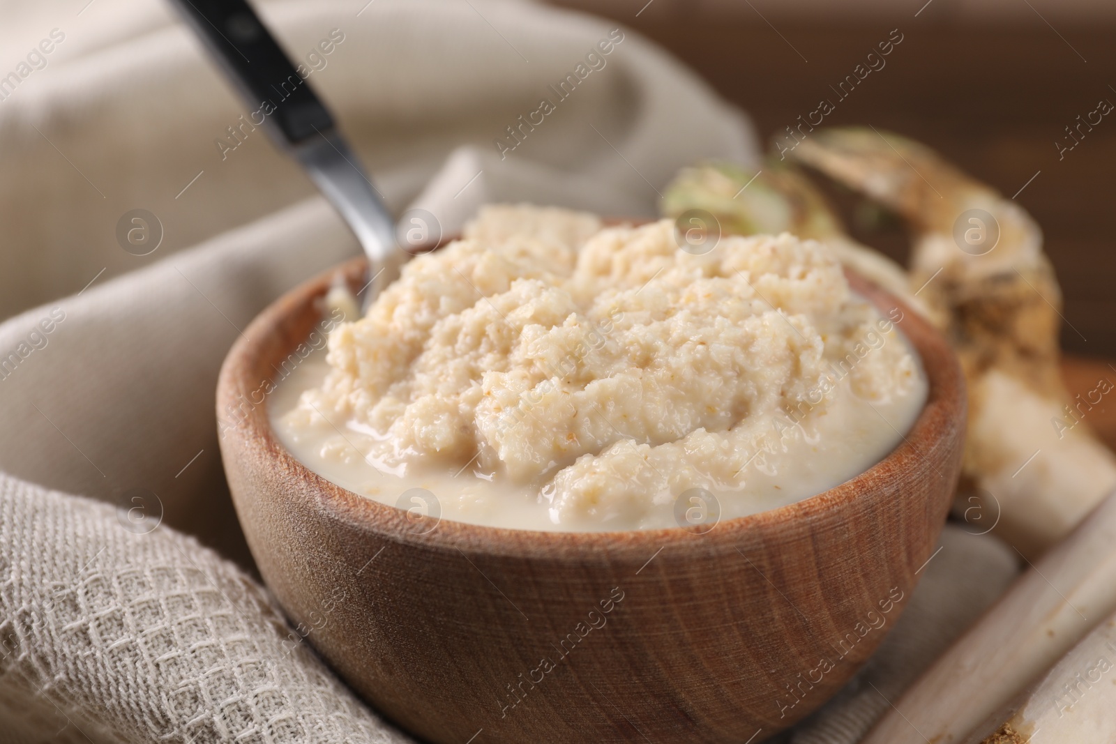 Photo of Spicy horseradish sauce in bowl on table, closeup