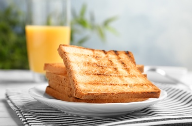 Photo of Plate with toasted bread on table