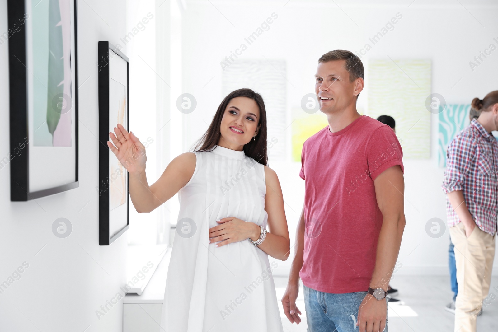 Photo of Young couple at exhibition in art gallery