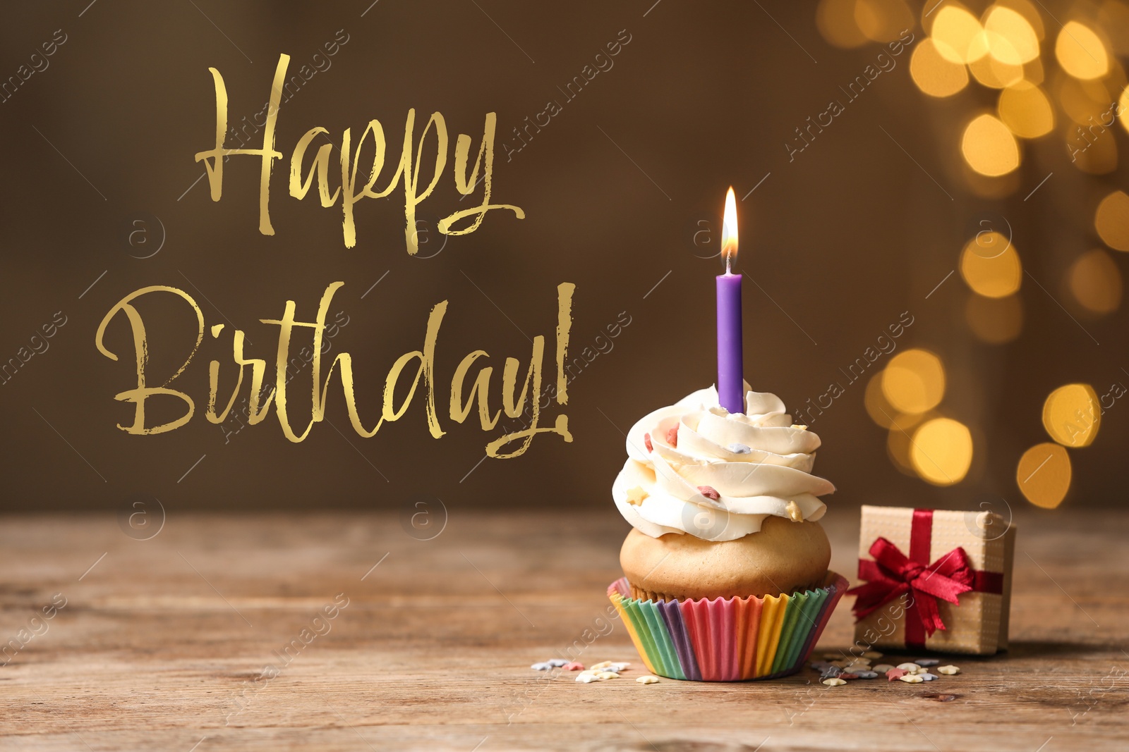 Image of Happy Birthday! Delicious cupcake with candle and gift box on wooden table