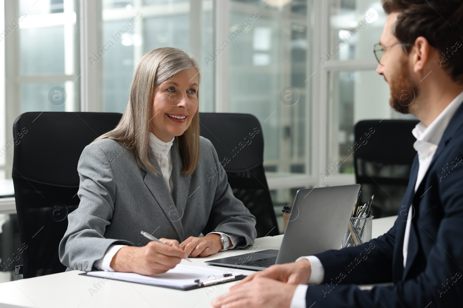 Photo of Lawyer working with client at table in office