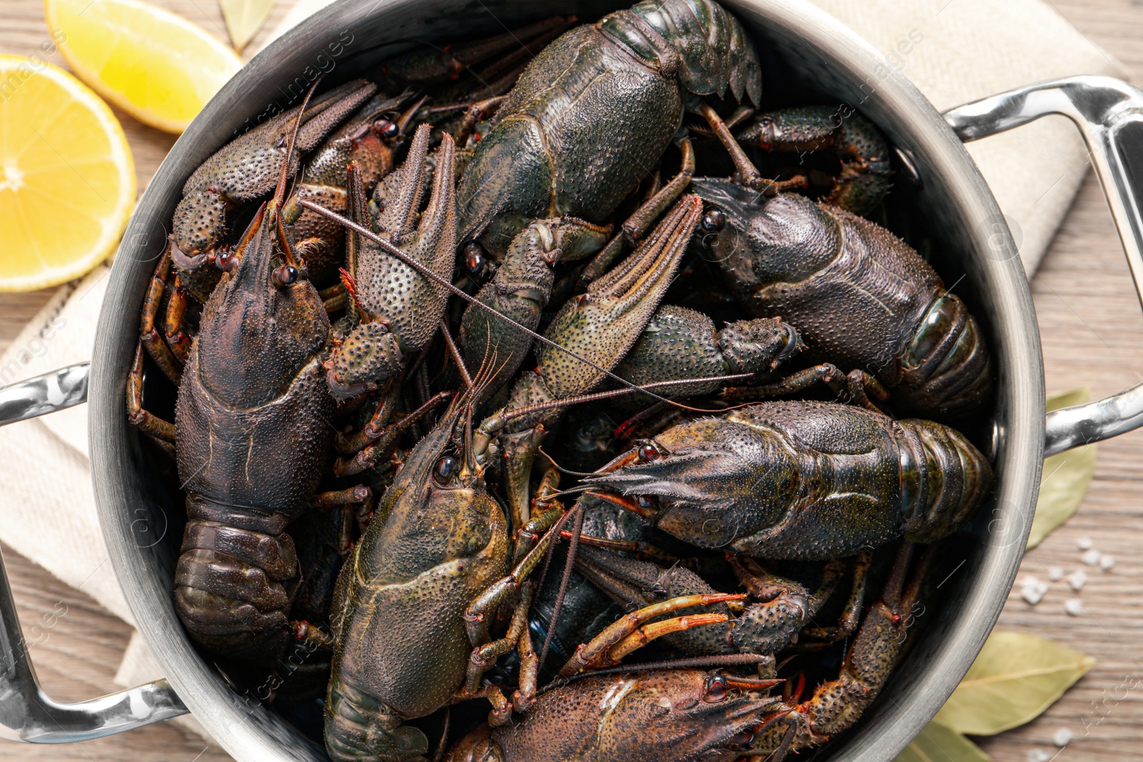 Photo of Fresh raw crayfishes in pot on table, flat lay