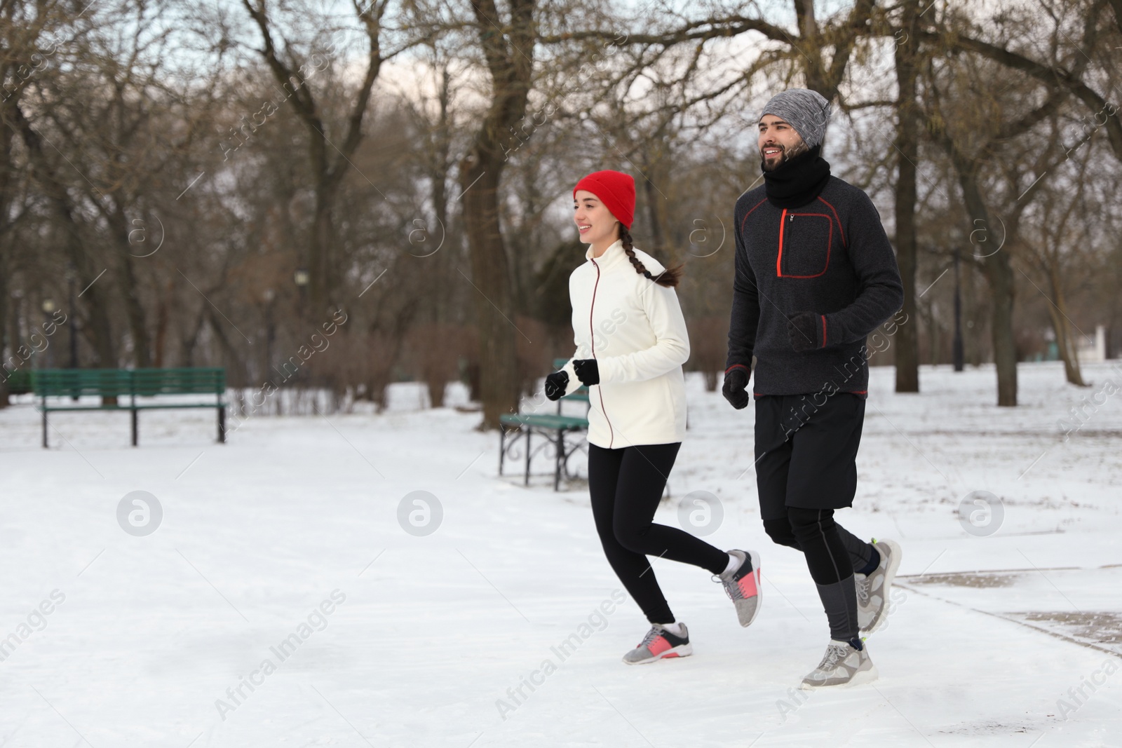 Photo of Happy people running in winter park. Outdoors sports exercises
