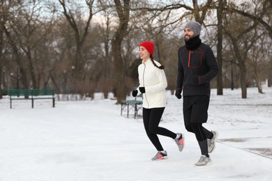 Happy people running in winter park. Outdoors sports exercises