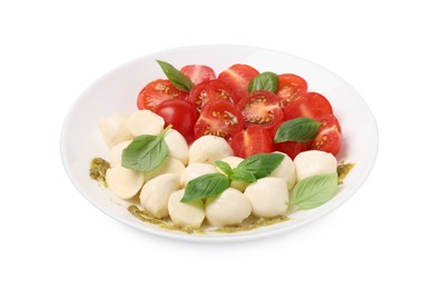 Plate of tasty Caprese salad with mozzarella, tomatoes, basil and pesto sauce isolated on white