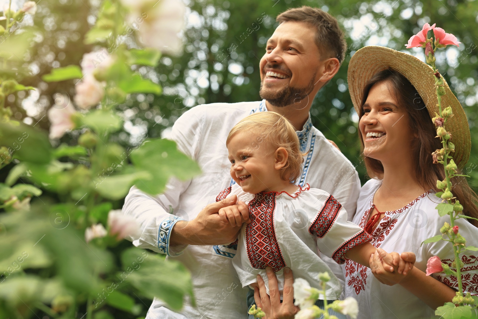 Photo of Happy family in Ukrainian national clothes outdoors