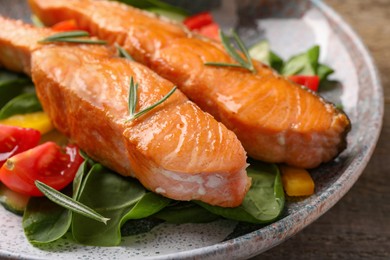 Photo of Healthy meal. Tasty grilled salmon with vegetables and spinach on wooden table, closeup