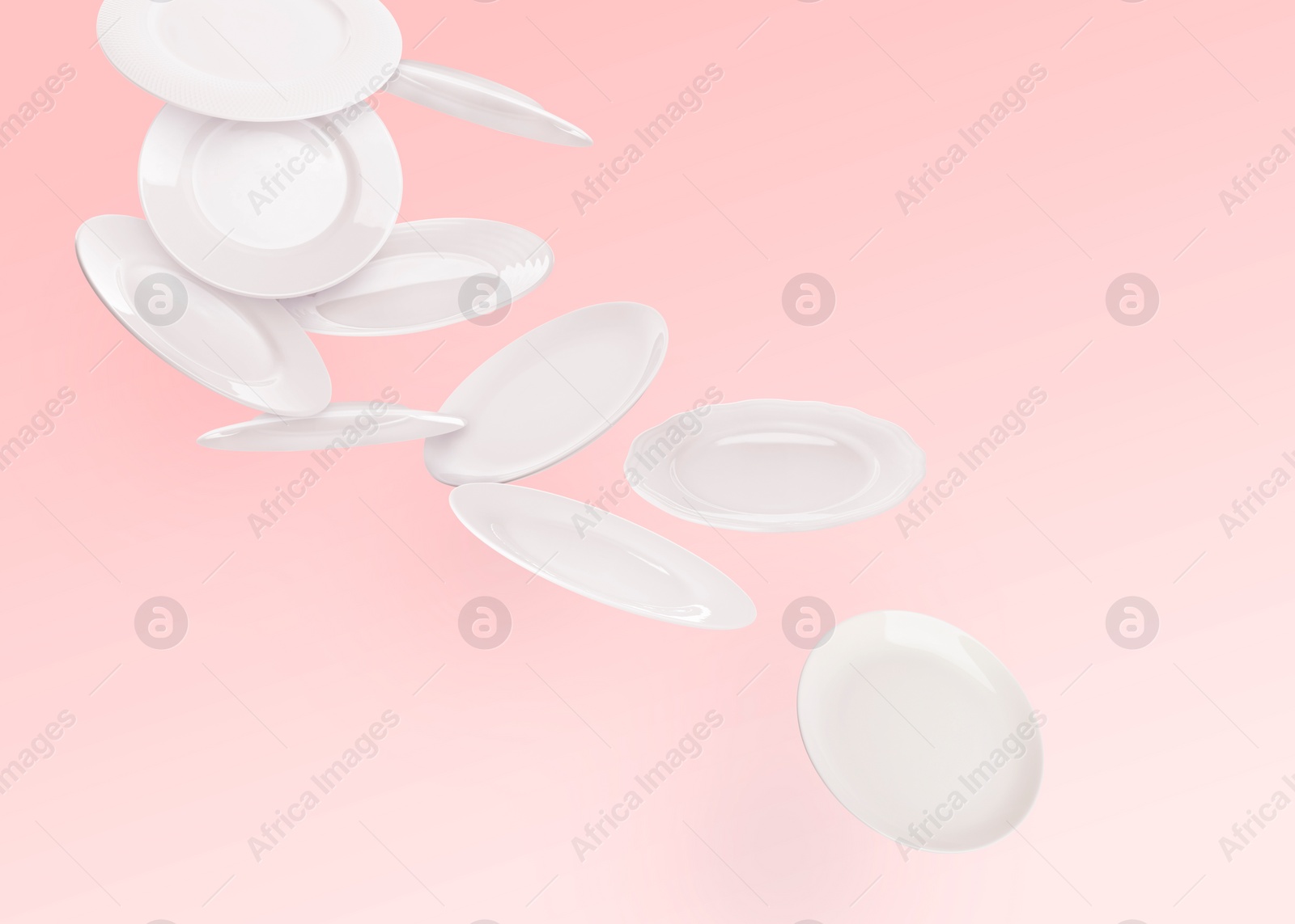 Image of Many white plates falling on pastel pink background