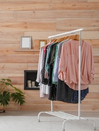 Photo of Wardrobe rack with stylish clothes in dressing room