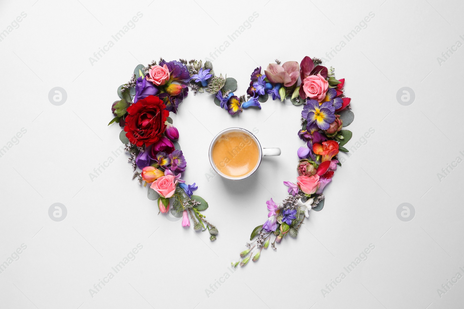 Photo of Beautiful heart shaped floral composition with cup of coffee on light background, flat lay