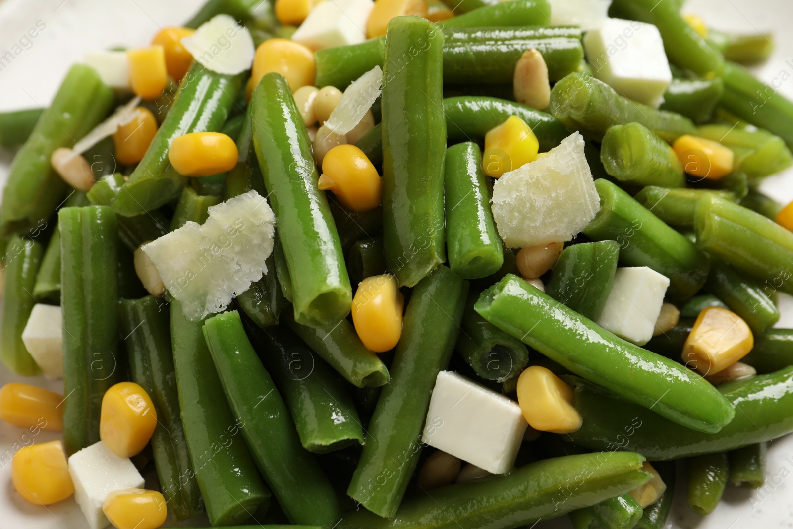 Photo of Delicious salad with green beans, corn and cheese, closeup