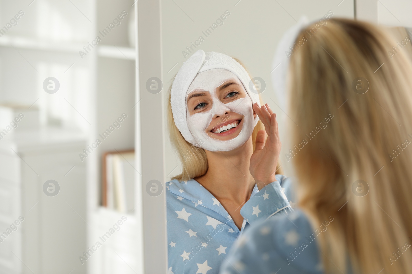 Photo of Young woman applying face mask at home, space for text. Spa treatments