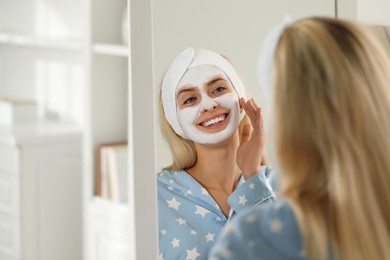 Photo of Young woman applying face mask at home, space for text. Spa treatments