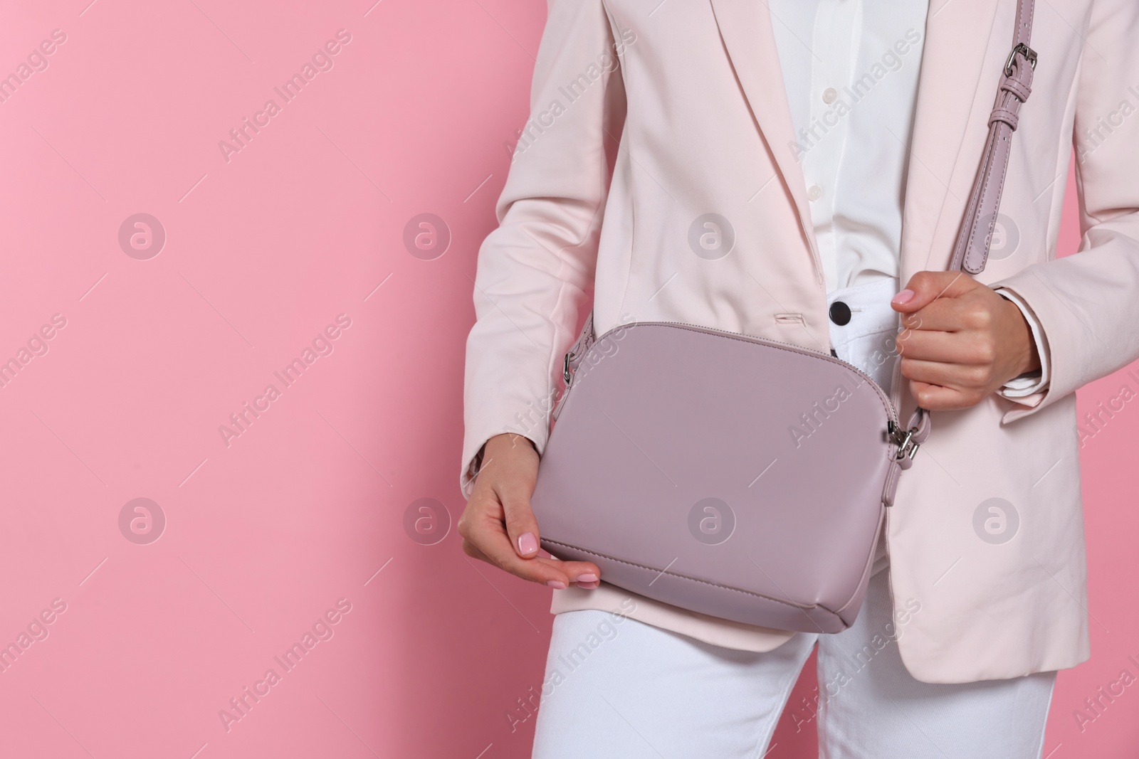 Photo of Woman with stylish bag on pink background, closeup. Space for text