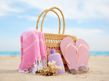 Different stylish beach objects and coral on sand near sea