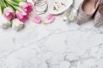 Photo of Flat lay composition of beautiful tulips and accessories on marble background, space for text. International Women's Day