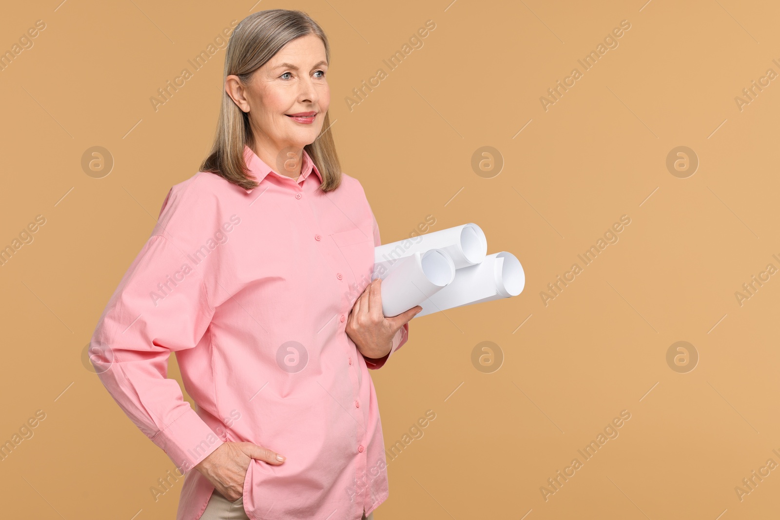 Photo of Architect with drafts on beige background, space for text