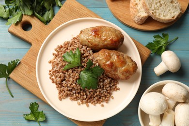 Photo of Tasty buckwheat with fresh parsley and cutlets on light blue wooden table, flat lay