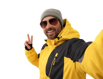 Smiling man in sunglasses taking selfie and showing peace sign on white background