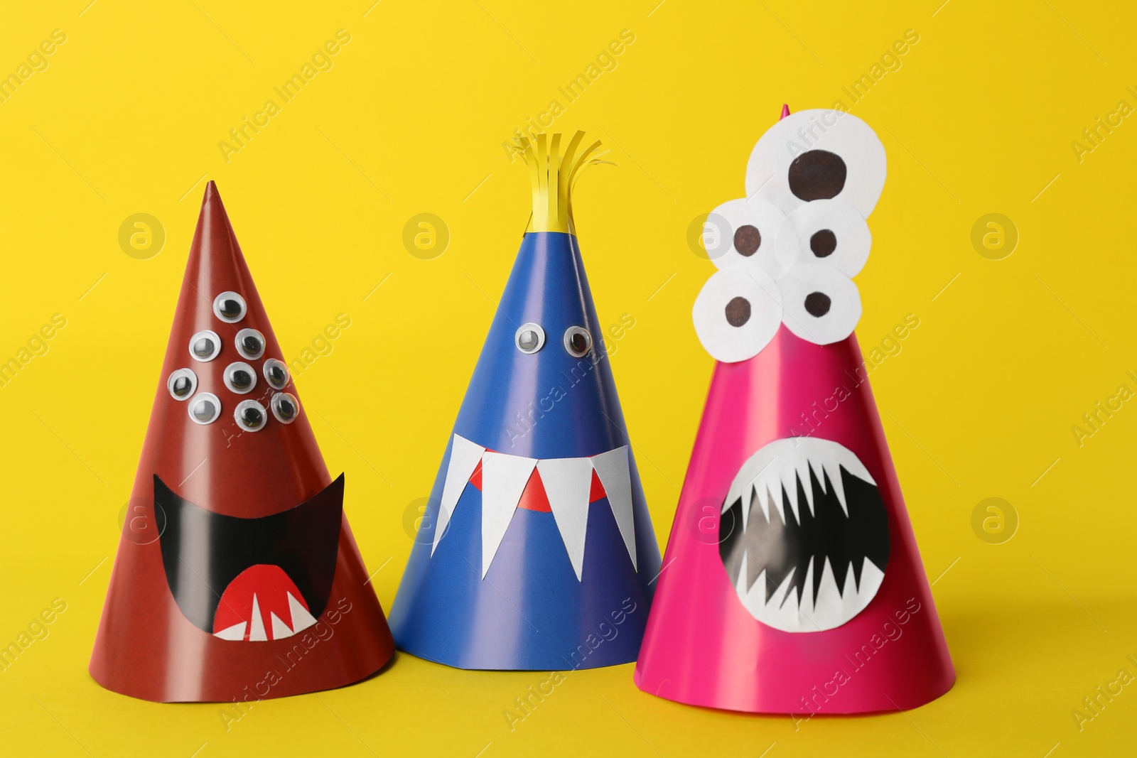 Photo of Funny monsters on yellow background. Halloween decoration