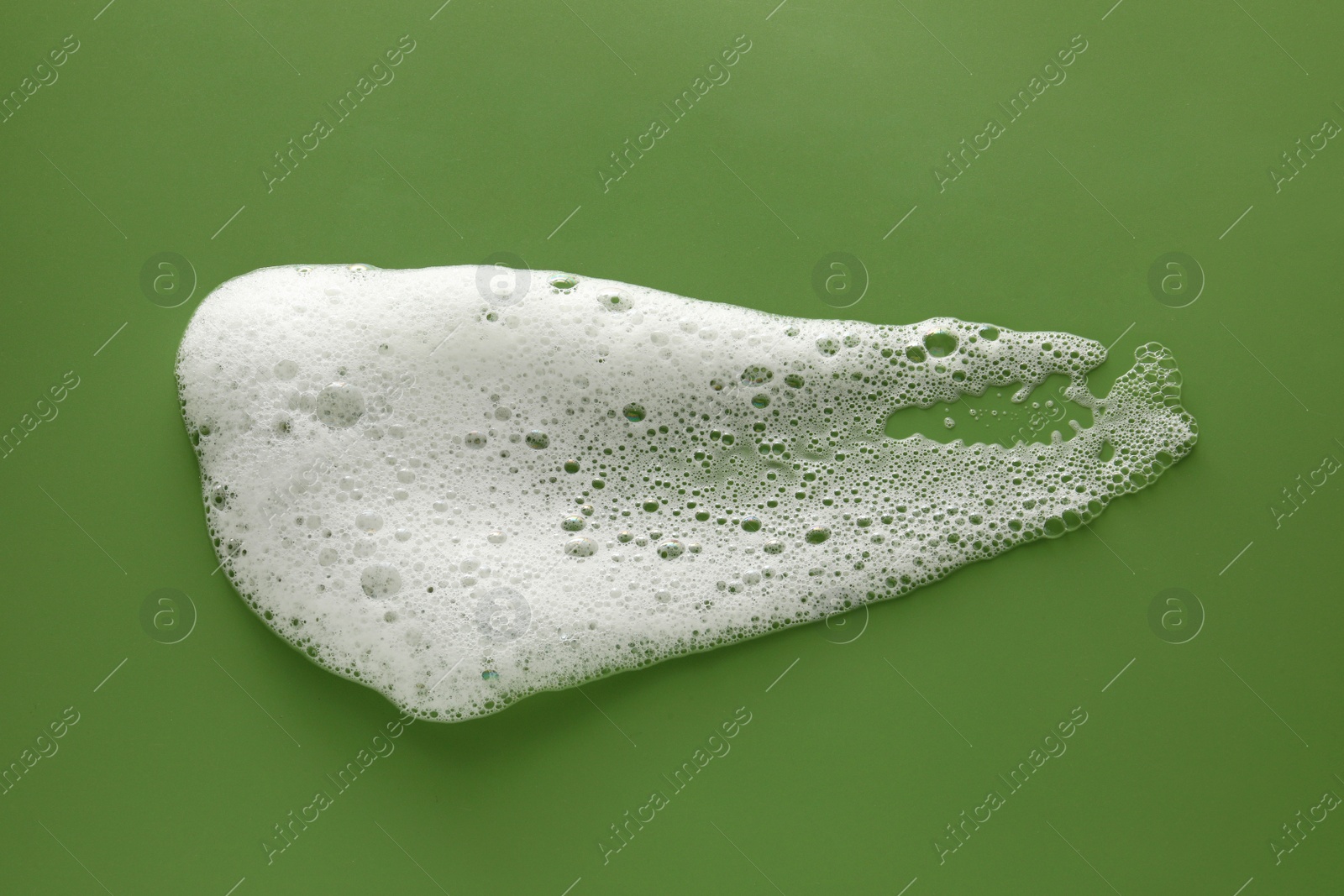 Photo of Smudge of white washing foam on olive background, top view