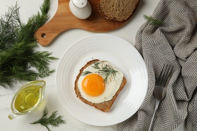 Plate with tasty fried egg, slice of bread, dill and fork on white marble table, flat lay