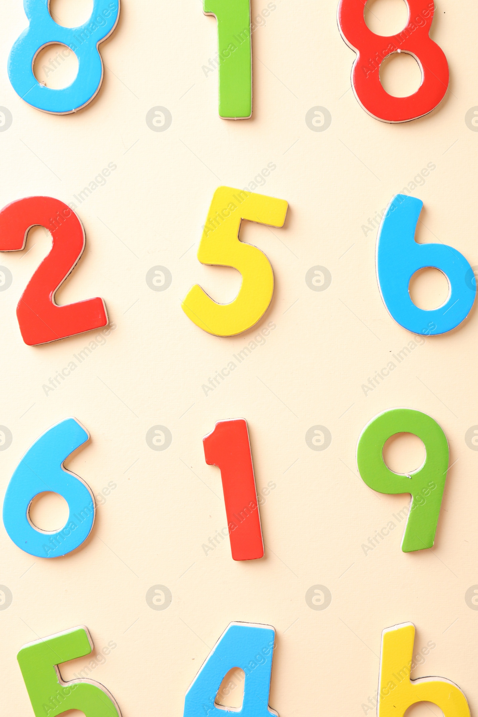 Photo of Colorful numbers on beige background, flat lay