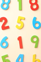 Colorful numbers on beige background, flat lay