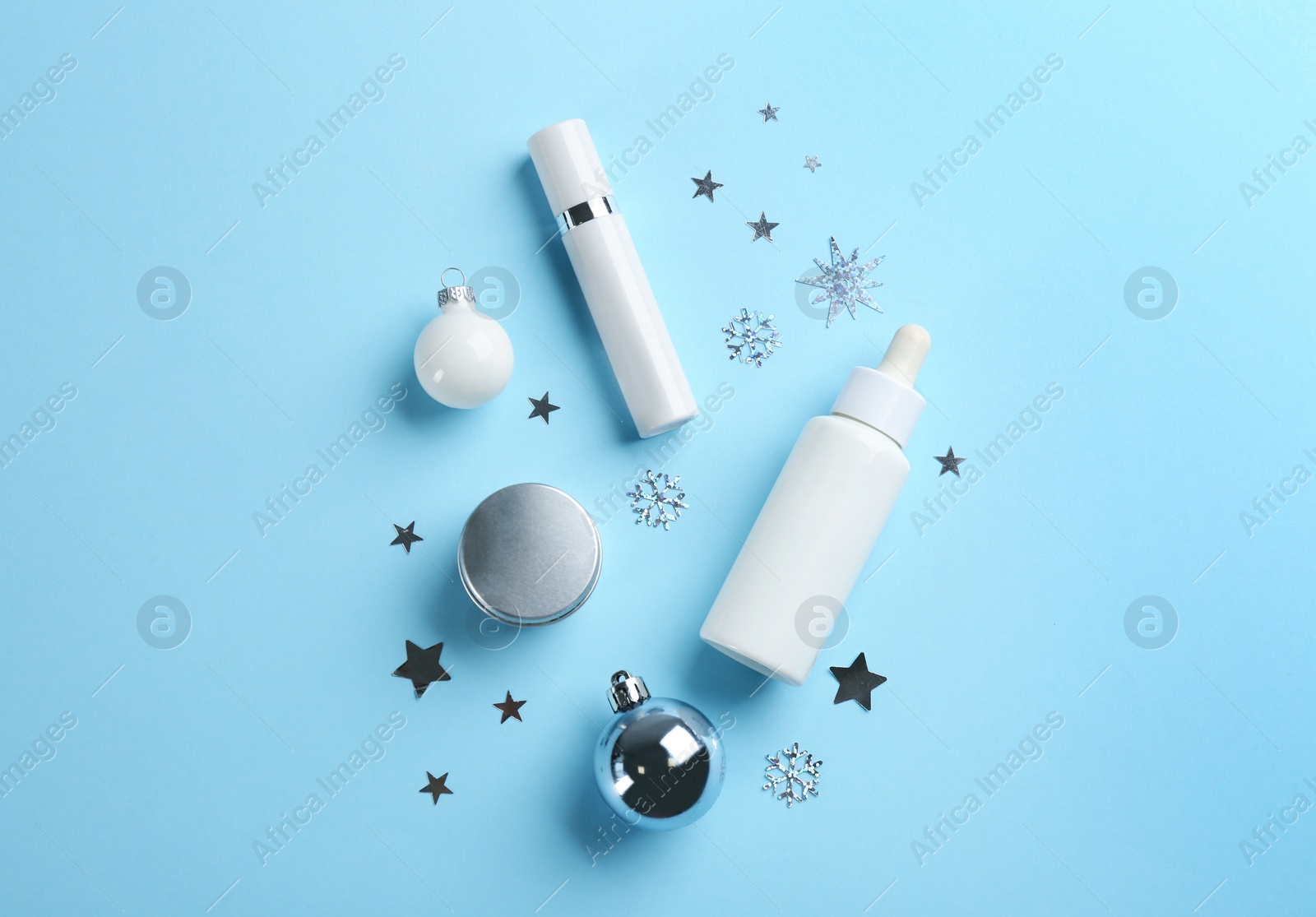 Photo of Flat lay composition with different cosmetic products on light blue background. Winter care