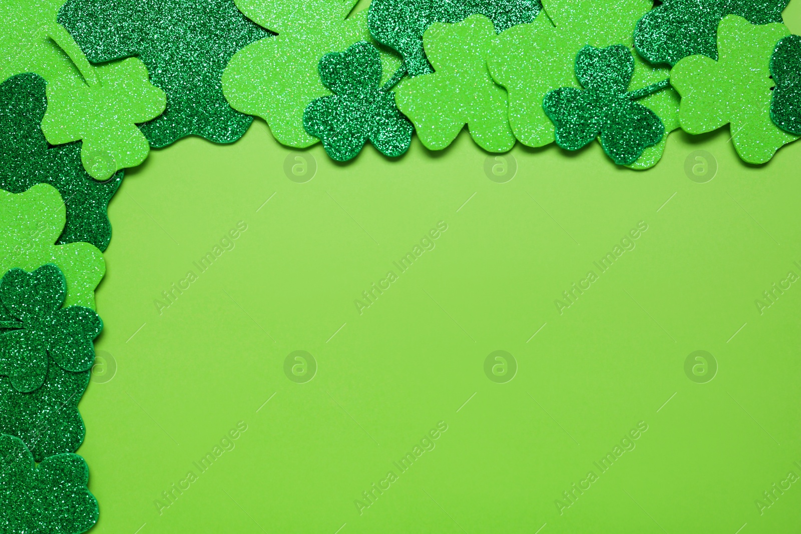 Photo of Flat lay composition with clover leaves on light green background, space for text. St. Patrick's Day celebration