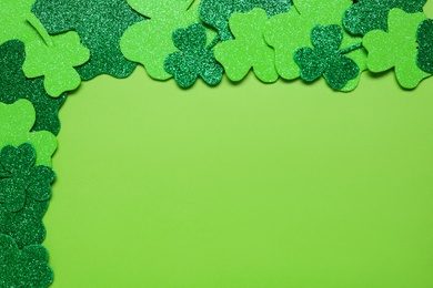 Flat lay composition with clover leaves on light green background, space for text. St. Patrick's Day celebration