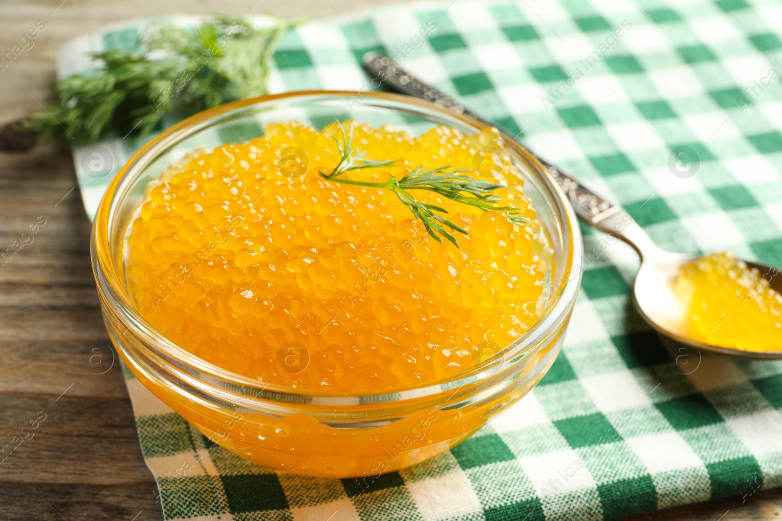 Photo of Fresh pike caviar in bowl on wooden table, closeup