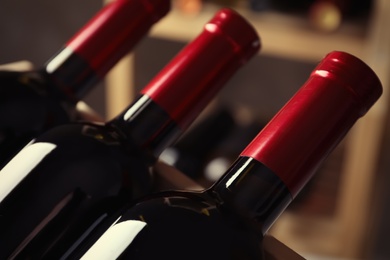 Photo of Bottles with delicious wine, closeup. Professional sommelier