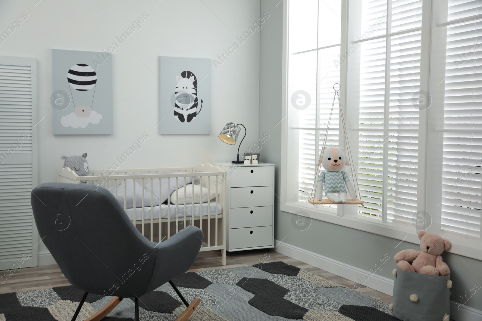 Photo of Stylish baby room interior with crib and rocking chair