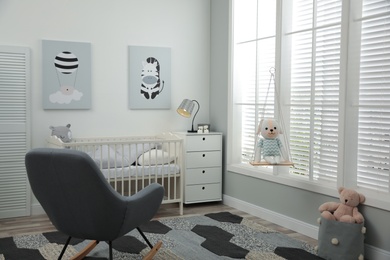 Stylish baby room interior with crib and rocking chair