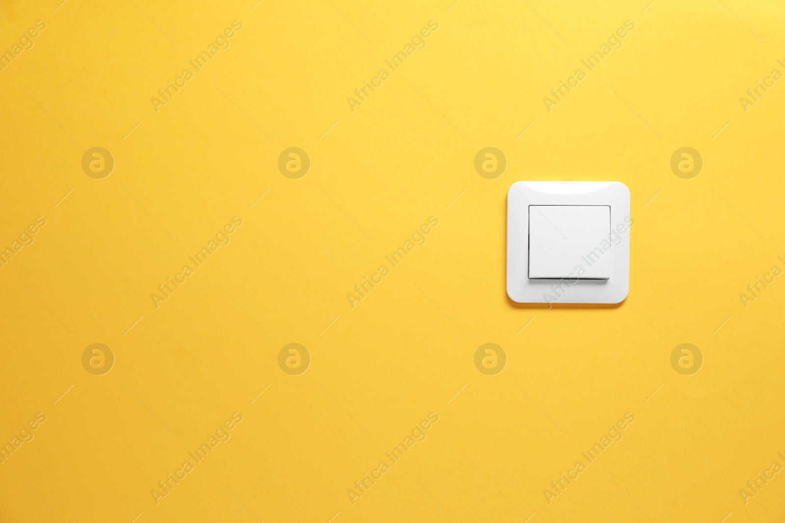 Photo of Modern plastic light switch on orange background. Space for text