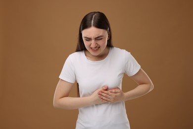 Photo of Woman having heart attack on brown background