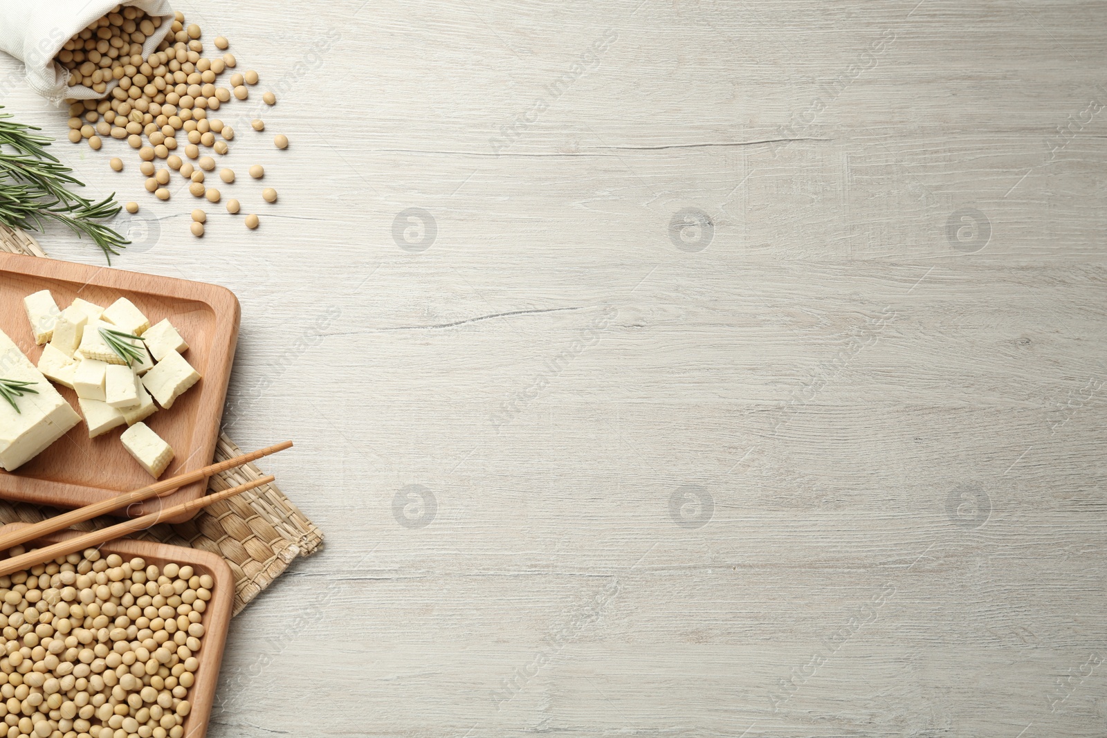 Photo of Pieces of delicious tofu with rosemary and soy on white table, flat lay, Space for text