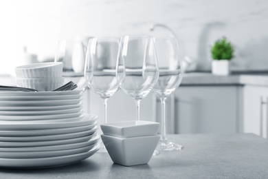 Set of clean dishes on table in kitchen. Space for text