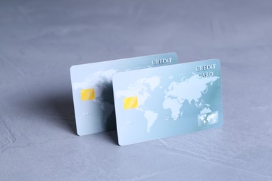 Photo of Two credit cards on grey textured table, closeup