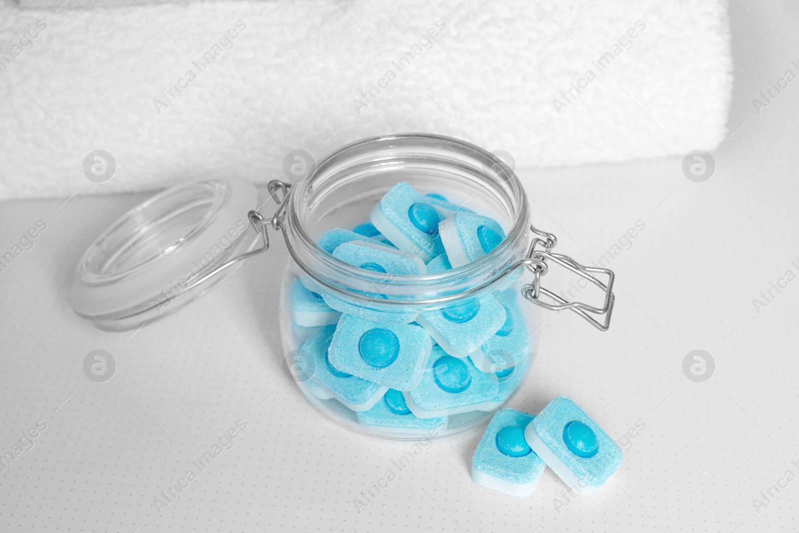 Photo of Jar with water softener tablets on white table, closeup