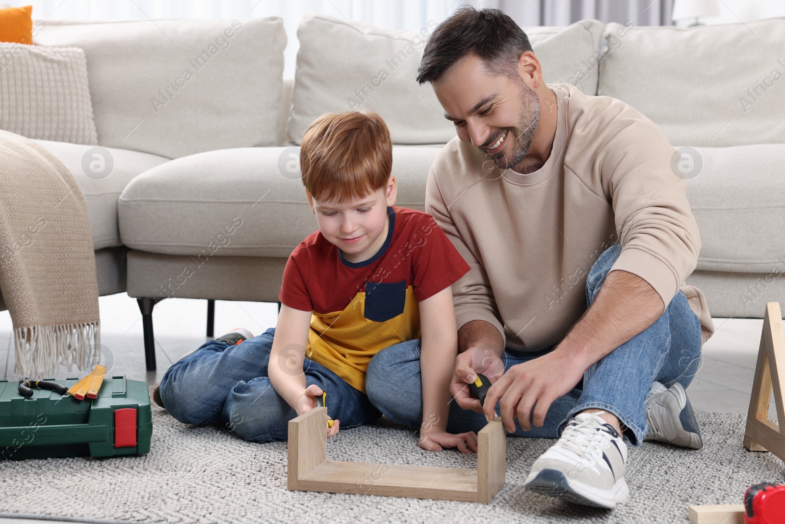 Photo of Father and son repairing shelf together at home